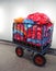 Metal cart for waste collection with a large pile of colorful plastic bags filled with sorted waste