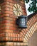 Metal carved lantern on a brick wall. Fragment of the urban landscape