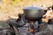 Metal cauldron boiling on a bonfire. Cooking on open fire