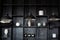 Metal chandeliers in retro style on background wooden shelves with decor. Dark room with Three modern lamps over table. Three mode