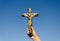 Metal cross crucified christ in hand on blue sky