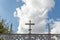 Metal cross located on the perimeter of a religious cemetery, on a sunny day