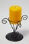 Metal curved black candlestick with thick yellow candle