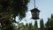 Metal dark brown lantern sways in the wind in the garden on a summer day