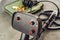 Metal detector and bunch of coins on wooden board