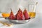 Metal dish with delicious poached pears in red wine on white table