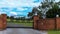 Metal driveway entrance gate set in brick fence