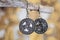 metal earrings in ornamental shape hanging on neutral background
