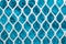 Metal enameled grid. abstract background. blue cloth behind the metallic grate