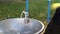 Metal faucet with drinking water fountain at city park near children playground at autumn outdoors. Drinkable water