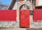 Metal Fence Door with red wild stone. Metal fencing exterior with door bell and postbox.