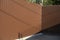 Metal fence with hidden video surveillance. Brown solid fence