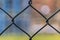 Metal fence netting, netting on a blurred background. Large metal mesh. Close-Up View Of Wire Fence