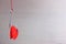 A metal fishing hook hanging on a rope pierced tow hearts of the red cardboard. Concept of love. Valentine`s day