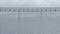 Metal foot bridge above the surface of the sea or ocean in cloudy overcast weather. Empty iron crosswalk on the calm water.