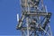 Metal frame of telecommunications tower in front of a dark blue sky