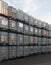 Metal framed intermediate bulk containers stacked on pallets waiting to be cleaned or reused in an industrial yard