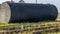 A metal fuel tank in an antique railway yard. Old black Fuel Tank on the village railroad station.