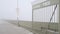 Metal gate of Ocean Beach pier in fog, misty boardwalk entrance California coast