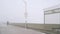 Metal gate of Ocean Beach pier in fog, misty boardwalk entrance California coast