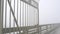 Metal gate of Ocean Beach pier in fog, misty boardwalk entrance California coast