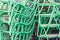 Metal green painted chairs with wooden sits piled outdoor next t