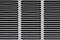 Metal grille for gray ventilation. Industrial background. Black horizontal and diagonal stripes on a gray background