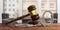 Metal handcuffs and judge gavel on wooden desk, blur office background. 3d illustration