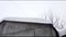 Metal hangar with roof covered with snowdrift in winter during snowfall, modern industrial exterior, panoramic view, 4K