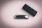 Metal harmonica and a black box on dirty pink background