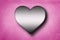 Metal heart shape on pink concrete wall background . 3D rendering