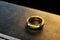 Metal heavy anvil and golden ring isolated on a dark background. 3D illustration, 3D render, photorealism