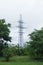 Metal high-voltage support, electric derrick against the sky, forest