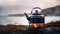 Metal kettle on campfire overlooking mountain lake