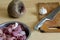 Metal kitchen knife, raw vegetables, cutting board and bowl of raw meat pieces