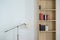 Metal lamp stand and wooden bookshelf with books