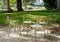 Metal lawn chairs arranged in a circle in a park