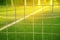 Metal net with blur green football or soccer summer field with w