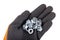 Metal nuts placed on the palm of a working glove. Accessories for mounting metal elements