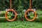 Metal orange rings on chains for gymnastics sport and fitness in the yard on the children`s playground in summer