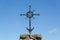 Metal ornamented cross on blue sky background