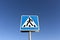 Metal pedestrian sign and blue sky