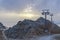 Metal pillars of the chairlift. Mountain slopes in summer. Away sea bay. Sunset