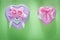 Metal pink heart-shaped present boxes on green background celebr