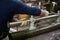 Metal pipe in the hands of a worker in the workshop for the manufacture of lamp posts. Product assembly process