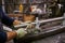 Metal pipe in the hands of a worker in the workshop for the manufacture of lamp posts. Product assembly process