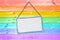 Metal plate sign hanging on a pastel colorful rainbow painted wood