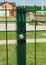 Metal post set in the ground with concrete footing of a metal railing fence