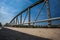 Metal railings on the bridge on sunny day. Road with c