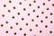 Metal rivets on pink glamourous background. Sample of stylish clothing products. Textured background. Fashionable rocker pattern